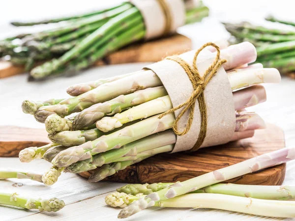 Fasci di asparagi verdi e bianchi su tavola di legno. Organic fo — Foto Stock
