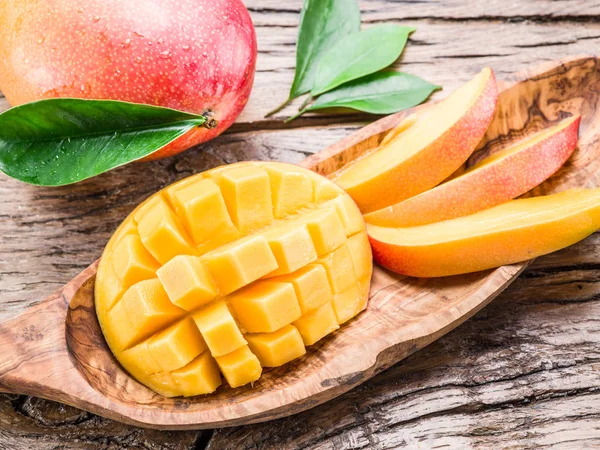 Mangofrüchte und Mangowürfel auf dem Holztisch. — Stockfoto