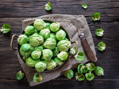 Eski ahşap masa üzerinde bakır tavada Brussel lahanası.