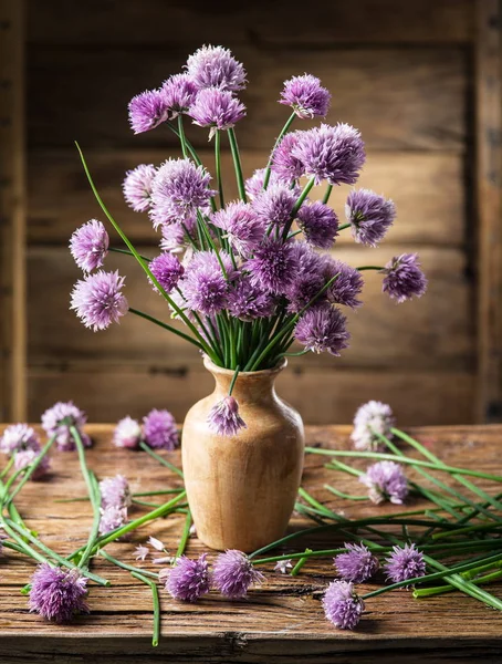 ネギ (チャイブ) 木製のテーブルの上の花瓶の花束 — ストック写真