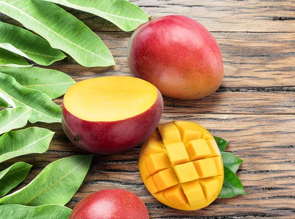 Frutti di mango e fette di mango sul vecchio tavolo di legno . — Foto Stock