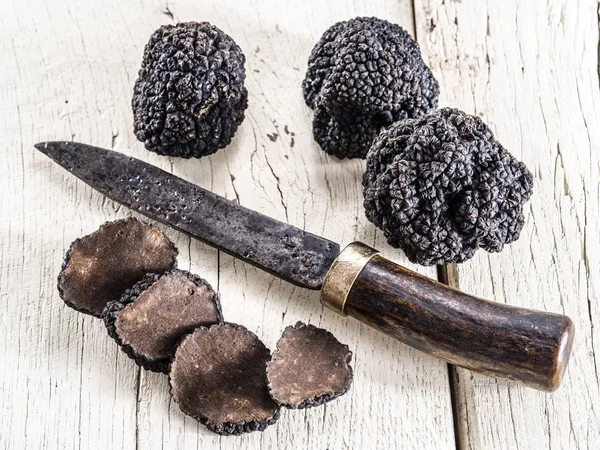 Black truffles on the old wooden table. — Stock Photo, Image