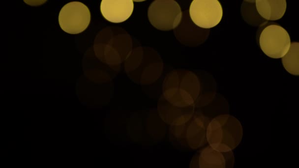 Defocused Bokeh Gele Kerstverlichting Langzaam Bewegen Zwarte Achtergrond — Stockvideo