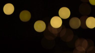 Kırmızı hediye kutularıyla Noel arkaplanı. Amera hediyeye yavaşça yaklaşıyor, ön planda ve arka planda Noel ışıklarıyla güzel Bokeh..