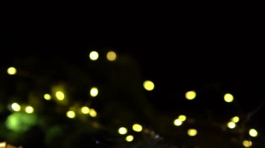 Kırmızı hediye kutularıyla Noel arkaplanı. Amera hediyeye yavaşça yaklaşıyor, ön planda ve arka planda Noel ışıklarıyla güzel Bokeh..