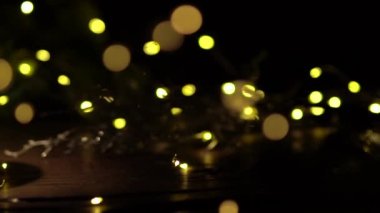 Kırmızı hediye kutularıyla Noel arkaplanı. Amera hediyeye yavaşça yaklaşıyor, ön planda ve arka planda Noel ışıklarıyla güzel Bokeh..