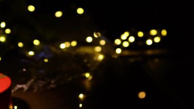 Kırmızı hediye kutularıyla Noel arkaplanı. Amera hediyeye yavaşça yaklaşıyor, ön planda ve arka planda Noel ışıklarıyla güzel Bokeh..