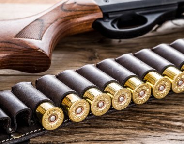 Pompa eylem av tüfeği, ahşap masa üzerinde 12 kalibre kartuş.