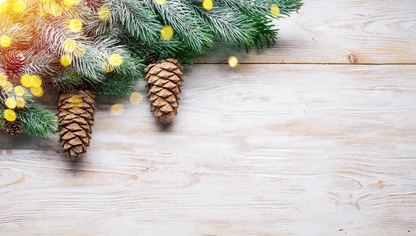 木製のテーブルの上にモミのコーンと雪のモミの枝。クリスマスかね — ストック写真