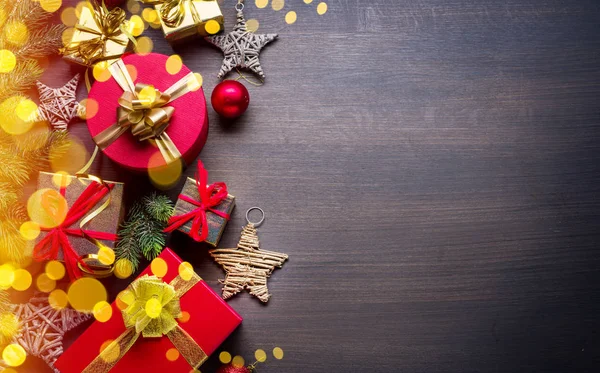 Decoración navideña, cajas de regalo y luces borrosas en madera oscura — Foto de Stock