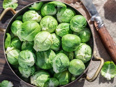 Eski ahşap masa üzerinde bakır tavada Brussel lahanası.