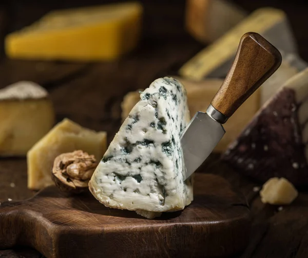 Segment of blue mould cheese and cheese knife on wooden board. D — Stock Photo, Image