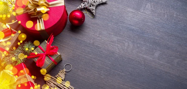 Χριστουγεννιάτικη διακόσμηση, κουτιά δώρων και θολή φώτα σε σκούρο ξύλο — Φωτογραφία Αρχείου