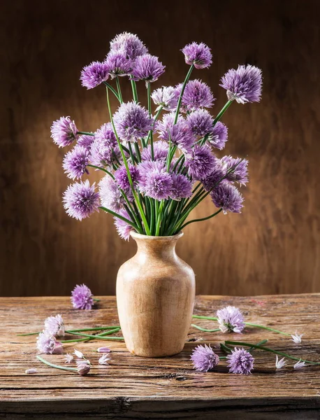 ネギ (チャイブ) 木製のテーブルの上の花瓶の花束 — ストック写真