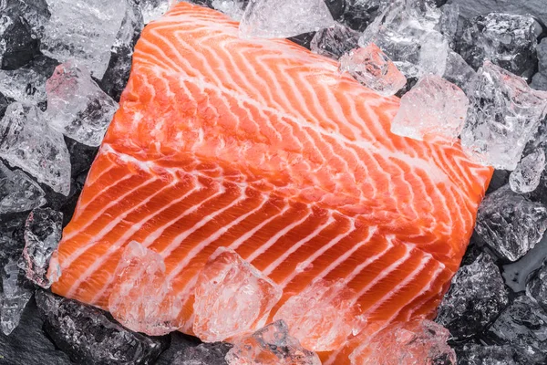 Filete de salmón fresco sobre hielo sobre tabla de cortar negra . —  Fotos de Stock