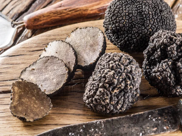 Trufas pretas na velha mesa de madeira. — Fotografia de Stock