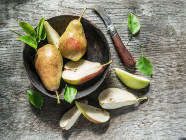 Bahçedeki ahşap masada olgun armutlar tabakta. Üst görünüm.