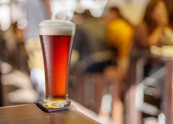 Glas rood bier staat op een tafel in een pub. — Stockfoto