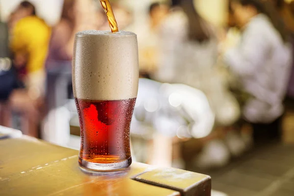 Glass of beer stands on a table in a pub. — Stock Photo, Image