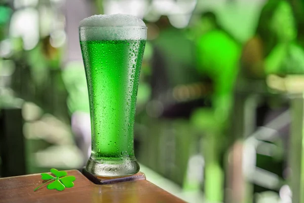 Egy pohár zöld sör áll az asztalon egy kocsmában a celebek alatt — Stock Fotó