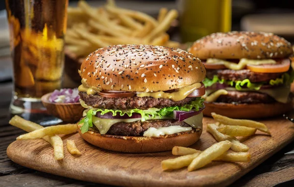 Hamburgers en frietjes op het houten dienblad. — Stockfoto