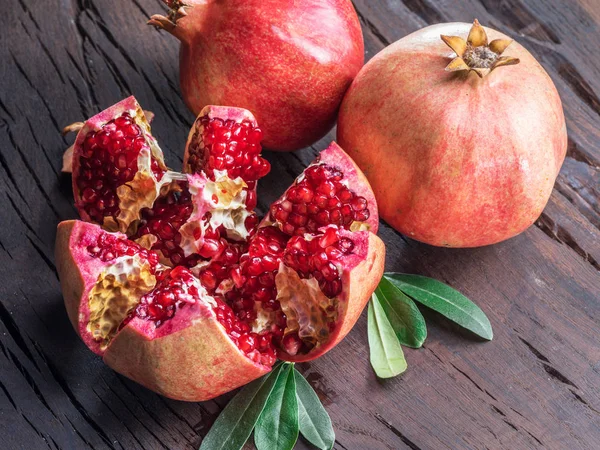 Rijpe granaatappel vruchten op houten tafel geopend. Bovenaanzicht. — Stockfoto