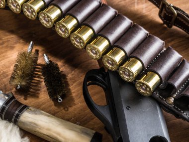 Av Ekipmanları - pompa eylem av tüfeği, 12 kalibre kartuş ve av bıçağı ahşap tablo.