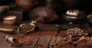 Tiramisu keki masaya düşüyor ve kakao tozunu havaya kaldırıyor. Tatlılar ve eski mutfak gereçleri için malzeme içeren koyu bir arka plan.. 