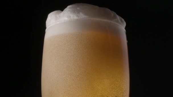黑色背景上的淡啤酒气泡和泡沫慢慢地爬到啤酒杯的顶部 按时间轮流 — 图库视频影像