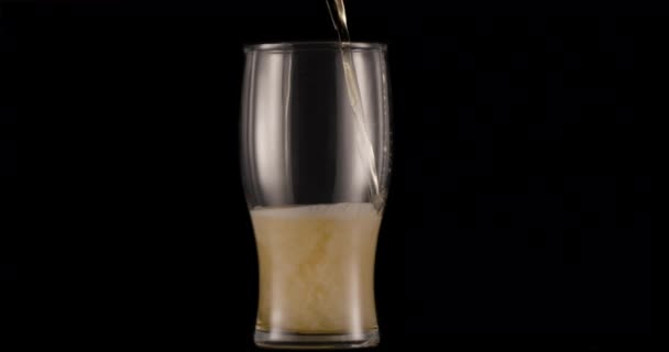 Vaso Cerveza Ligera Sobre Fondo Negro Chorro Lentamente Llena Vaso — Vídeo de stock