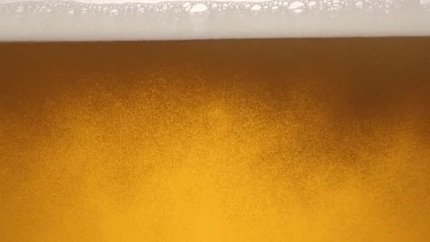 对一杯啤酒的内容进行特写 啤酒慢慢地在杯子 气泡和泡沫中摇曳 — 图库视频影像