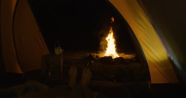 Турист Вночі Наметі Зігріває Втомлені Ноги Перед Вогнем Зсередини Горизонті — стокове відео