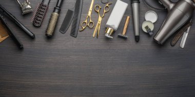 Ahşap arka planda klasik kuaför ve kuaför aletleri. Koyu renk ahşap masada duran berber dükkanının enstrümanlarının üst görüntüsü.