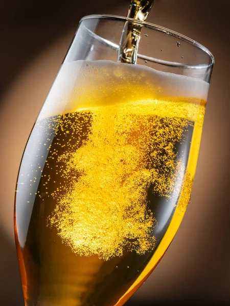 啤酒被倒入啤酒杯中 造成大量气泡和泡沫 深褐色背景 — 图库照片
