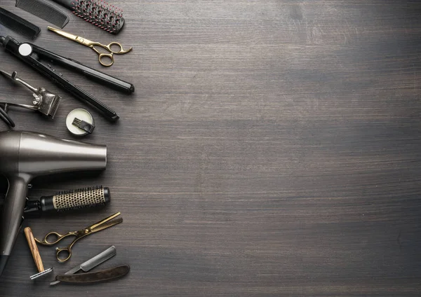 Classic grooming and hairdressing tools on wooden background. Top view on barbershop instruments  laying on dark wooden table.