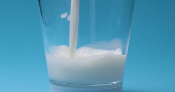 牛奶倒入蓝色底色的牛奶杯中 — 图库视频影像