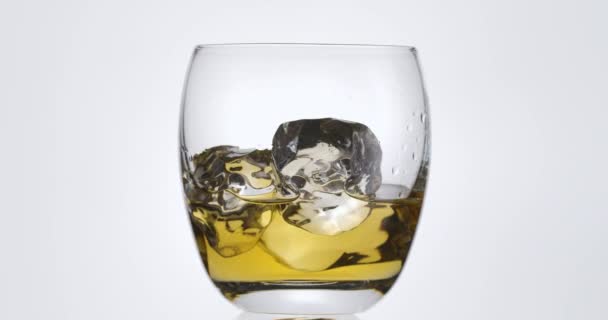 Cubos Gelo Caem Lentamente Copo Seguida Uísque Rum Derramado Fundo — Vídeo de Stock