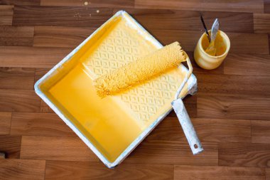 Duvar boyama araçları yerde yatıyor. Boyalı duvar rengi, sarı renk, konsept tasarım.