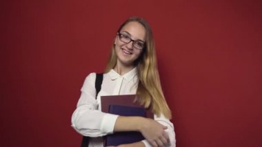 Çekici öğrenci sarışın kız kırmızı üzerinde gülümseyen