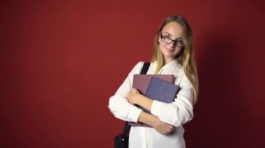 Çekici öğrenci sarışın kız kırmızı üzerinde gülümseyen