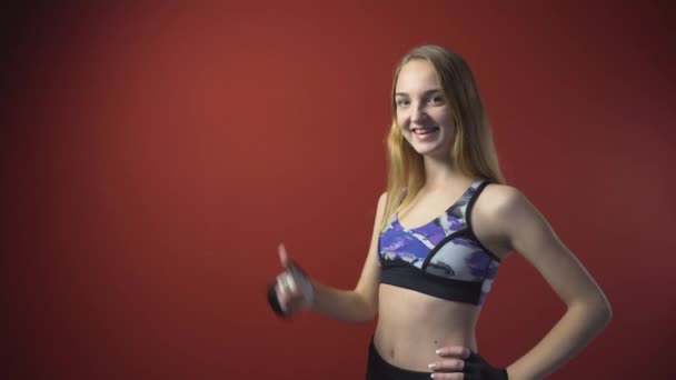 Jonge aantrekkelijke Fitness meisje duimschroef opwaarts — Stockvideo