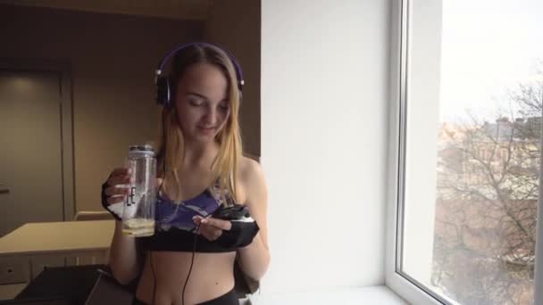 Chica rubia escuchando música en Fitness Break — Vídeo de stock