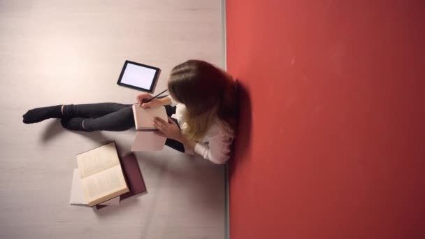Επίμονη νεαρός φοιτητής κορίτσι σπουδάζει στο πάτωμα — Αρχείο Βίντεο