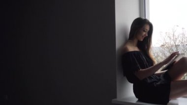 Pencere kenarında oturan çekici kız silüeti