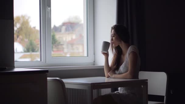 Atractiva mujer morena con taza de café blanco — Vídeos de Stock