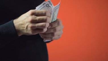 Siyah sakallı adam dolarlık banknotlar sayar