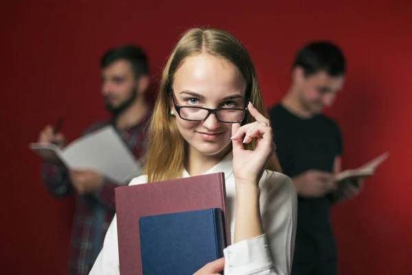 Aantrekkelijke Student blond meisje met bril op rood — Stockfoto