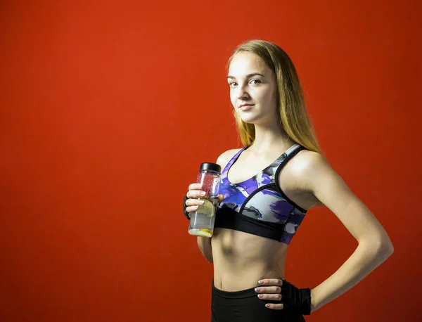 Joven atractiva chica de fitness con botella de deporte — Foto de Stock