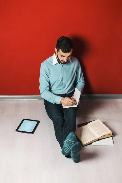 Estudiante joven persistente que estudia en el piso —  Fotos de Stock