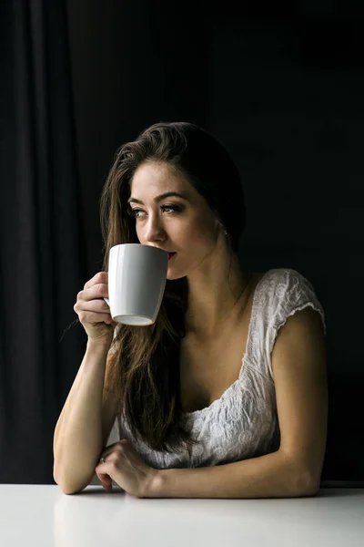 Atractiva mujer morena con taza de café blanco — Foto de Stock